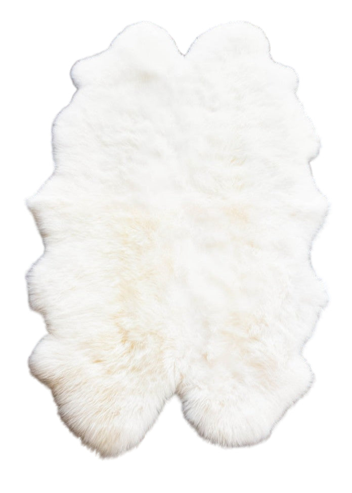 White fur rug on a brown surface
