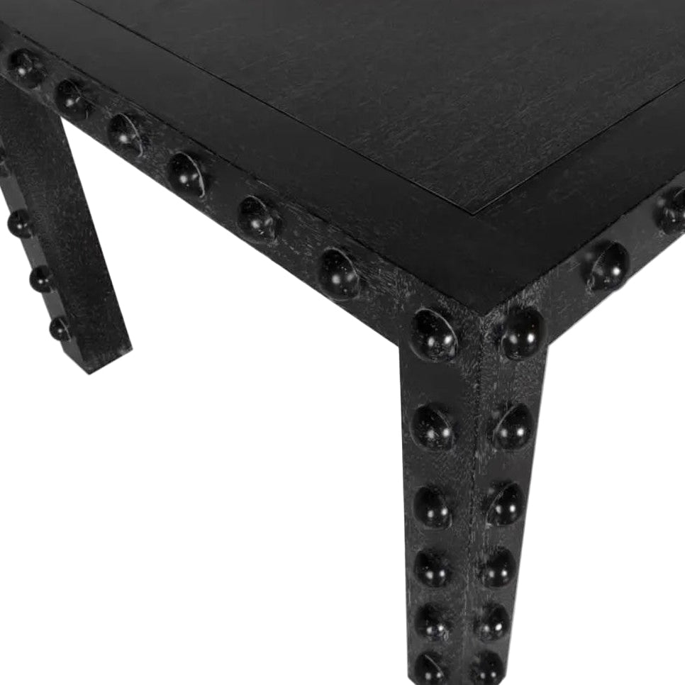 Black wood and metal table with rivet details on a white background