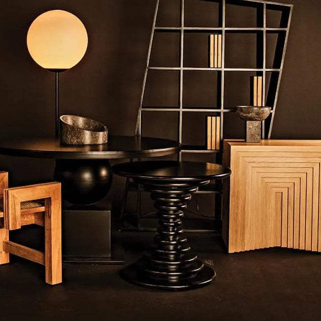 Modern interior with black and wooden furniture against a dark wall.