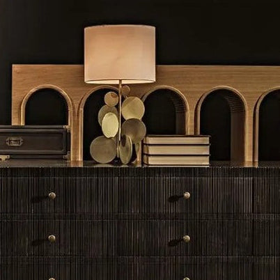 Dark wooden dresser with decorative items against a dark wall